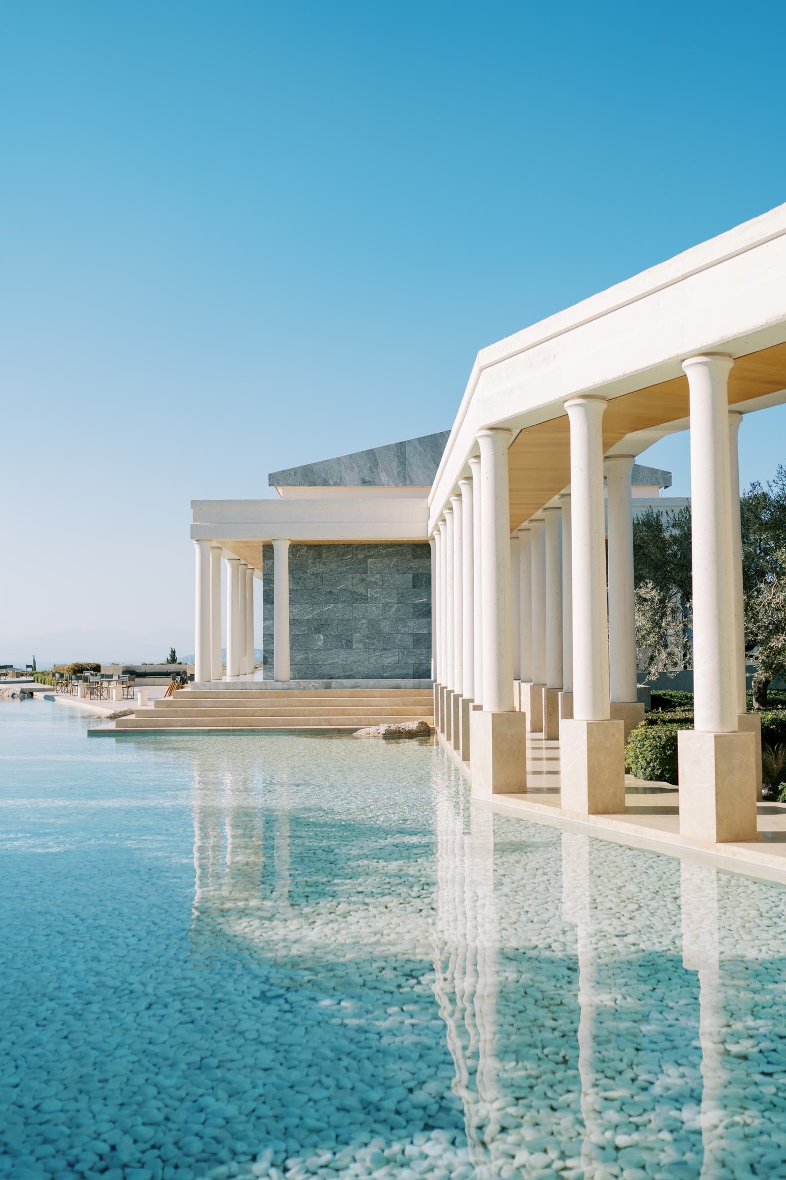 A contemporary waterside property framed by stone columns
